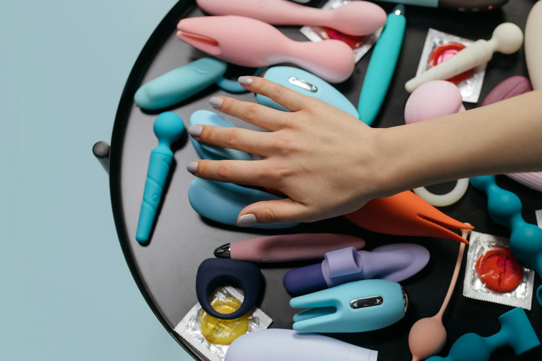 Close-up of hands holding a blue personal massager against a knitted sweater