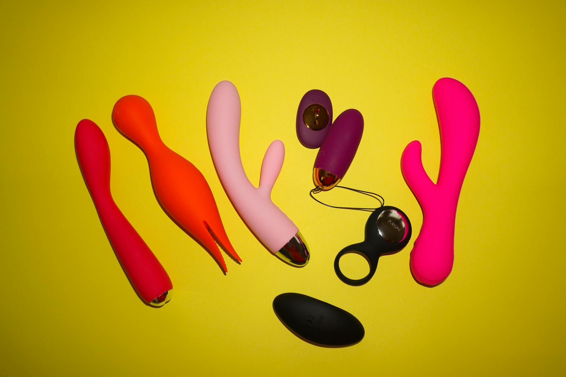 Blue clitoral vibrator held gently in hand against purple background