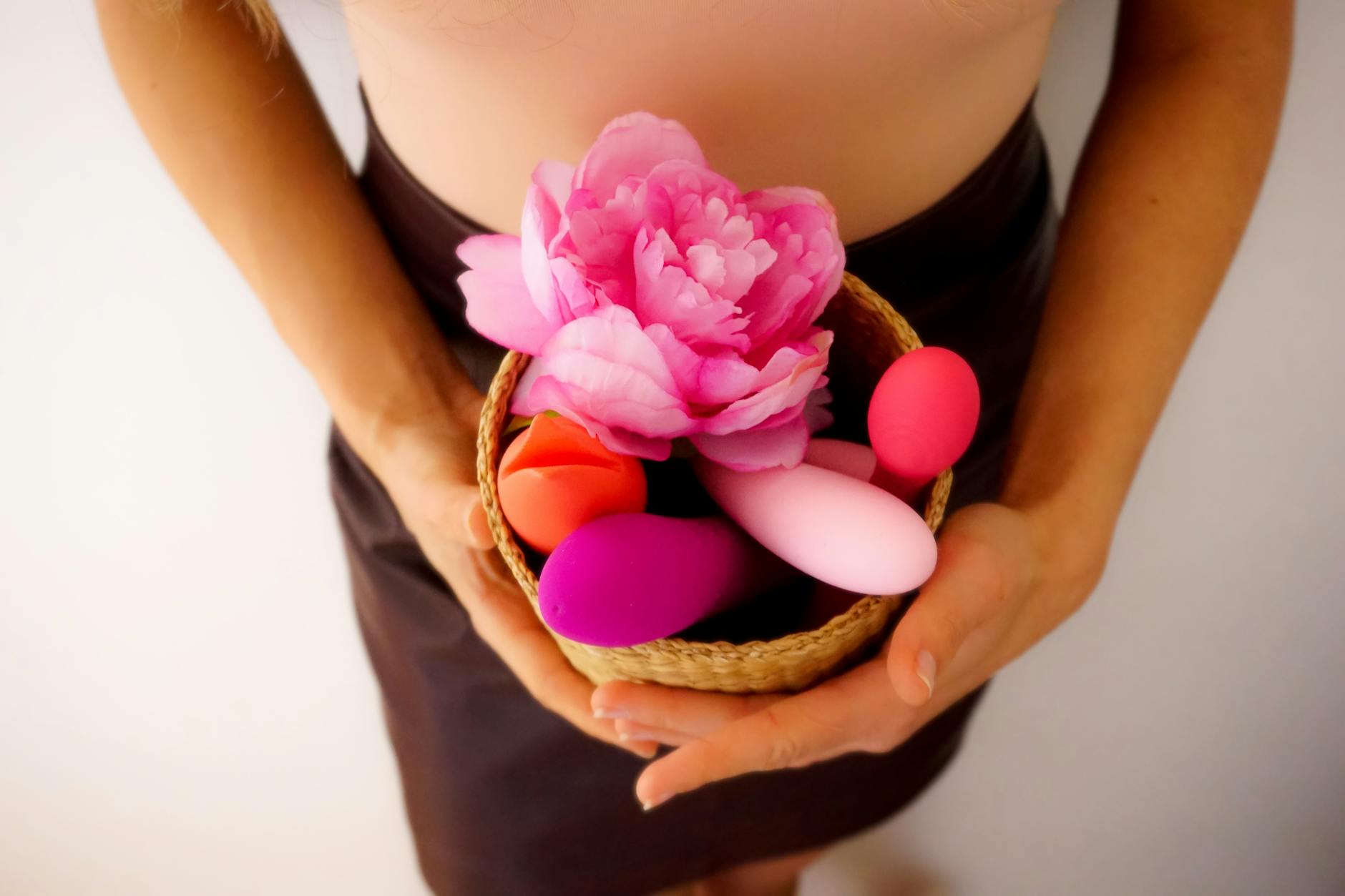 Colorful vibrators displayed in a basket, representing diverse pleasure options for adult wellness.