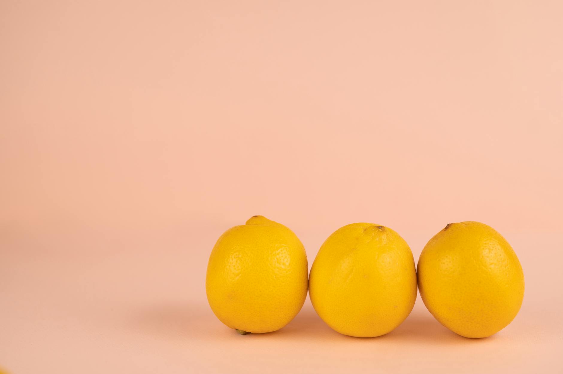 A close-up of a woman holding a fresh lemon at a dining table